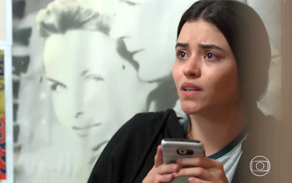 K1 (Talita Younan) com o celular na mão e expressão tensa em cena de Malhação - Viva a Diferença
