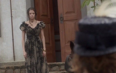 Domitila (Agatha Moreira) em frente a uma casa com cara de espanto diante de Leopoldina (Leticia Colin) em Novo Mundo