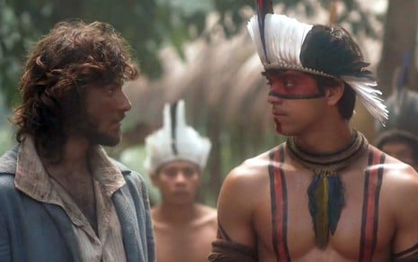 Joaquim (Chay Suede) conversa com Piatã (Rodrigo Simas) na aldeia em cena de Novo Mundo