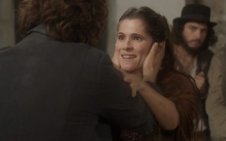 Joaquim (Chay Suede) segura o rosto de Elvira (Ingrid Guimarães) em cena de Novo Mundo