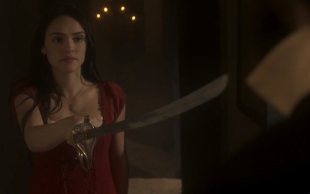 Anna (Isabelle Drummond) ameaça Thomas (Gabriel Braga Nunes) com uma espada em cena de Novo Mundo