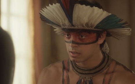 Piatã (Rodrigo Simas) vestido com trajes indígenas em cena de Novo Mundo