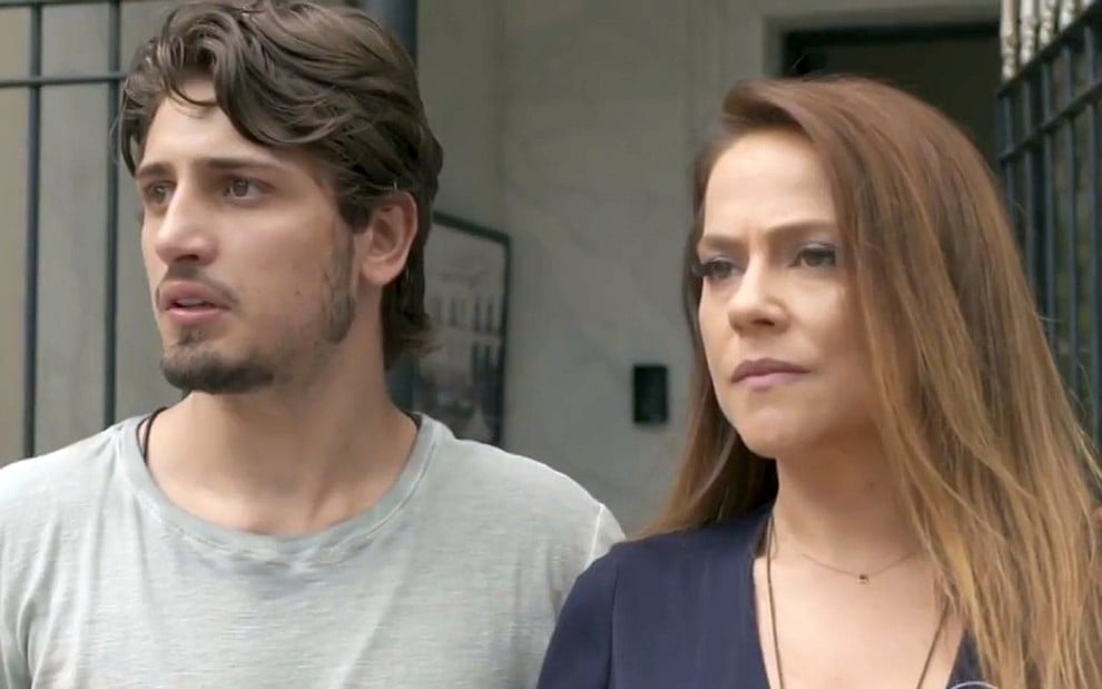 Rafael (Daniel Rocha) e Lili (Vivianne Pasmanter) olhando na mesma direção na porta de um prédio em cena de Totalmente Demais