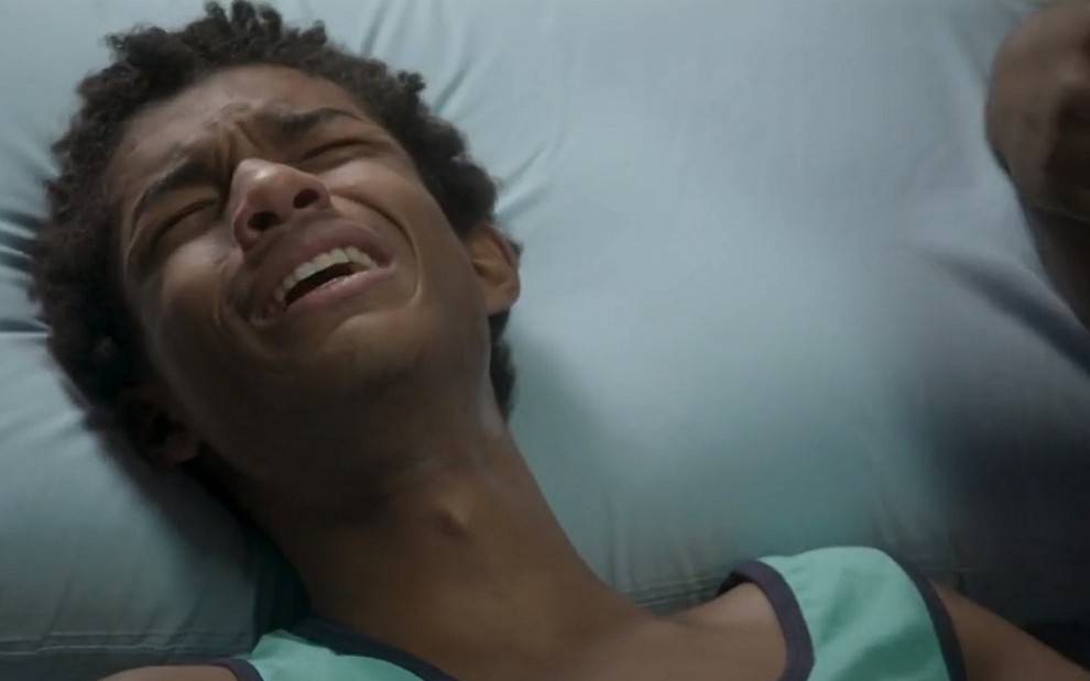 Wesley (Juan Paiva) chora na cama do hospital em cena de Totalmente Demais