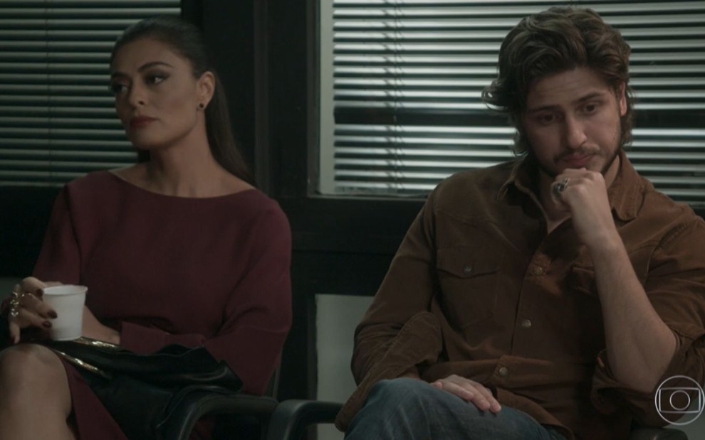 Carolina (Juliana Paes) e Rafael (Daniel Rocha) sentados esperando em cena de Totalmente Demais