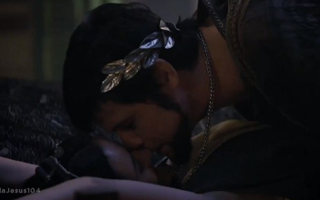 Antipas (Marcos Winter) e Temima (Elisa Romero) se beijam deitados em uma cama em cena de Jesus