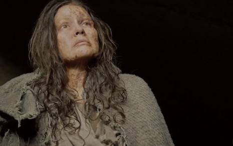 Cassandra (Juliana Boller) com feridas no rosto olha para cima em cena de Jesus