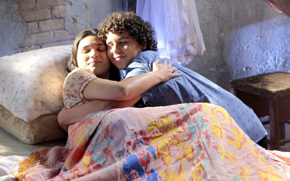 João (Igor Jansen) abraça a mãe, Josefa (Luciana Vidal), na cama em cena de As Aventuras de Poliana