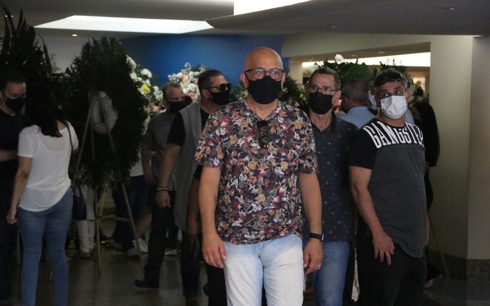 Ricardo Feghali, de máscara preta e camisa de manga curta, cercado por algumas pessoas