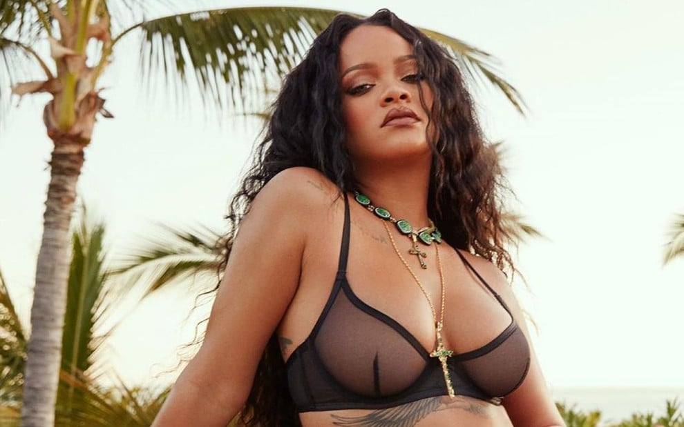 Rihanna de cabelo solto, cacheado, com sutiã transparente