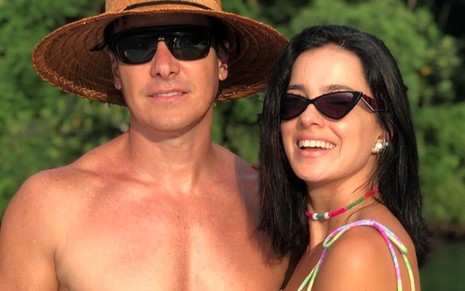 Rodrigo Faro, sem camisa, abraçado a sua mulher, Vera Viel, ambos de óculos escuros, em close