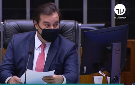 De máscara, o presidente da Câmara dos Deputados Rodrigo Maia comanda sessão plenária