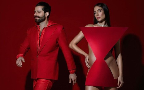 DJ Alok de terno e calça vermelhos; Romana Novais nua com peça geométrica cobrindo do corpo