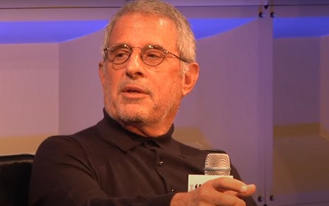 Sentado em uma poltrona e com um microfone na mão, Ron Meyer aparece em evento realizado nos Estados Unidos