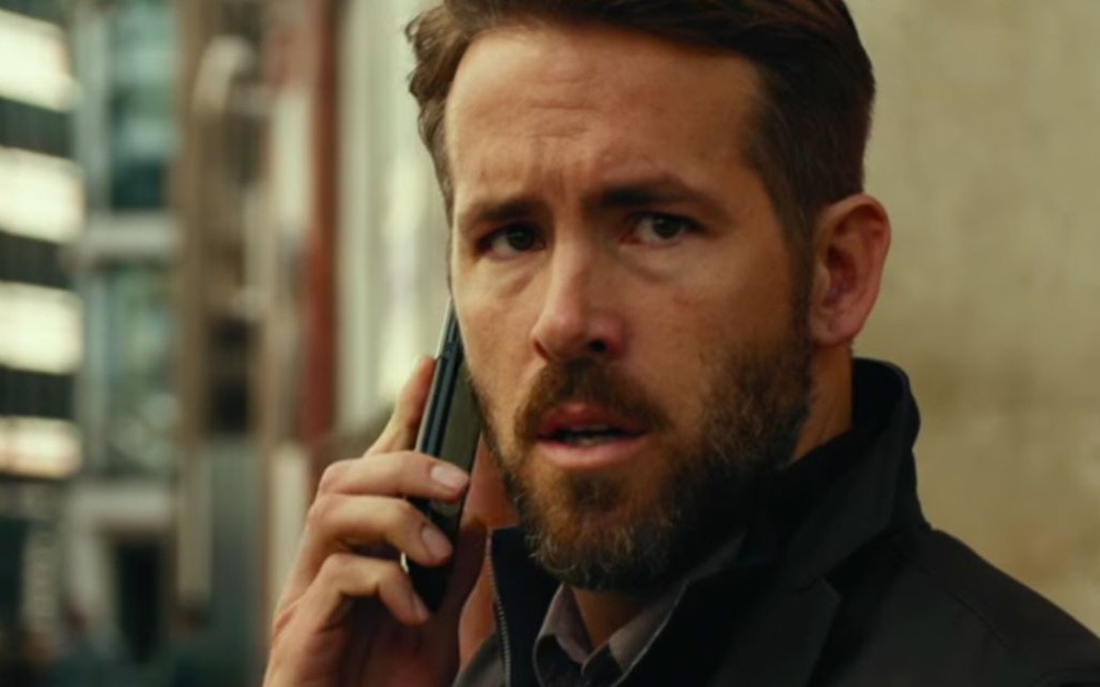 O ator Ryan Reynolds falando ao celular no filme Mentes Criminosas (2016)