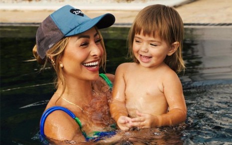 Sabrina Sato sorri e segura a filha Zoe na piscina