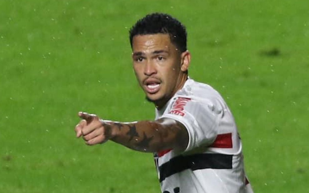 O atacante Luciano aponta o dedo para frente enquanto corre em jogo do São Paulo no Brasileirão