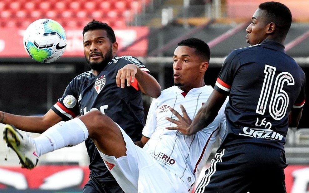 Os são-paulinos Reinaldo (à esq.) e Léo disputam bola com Marcos Paulo, do Fluminense, ao centro da imagem
