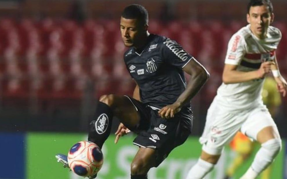 Um jogador do Santos disputa a bola com outro do São Paulo em duelo no Morumbi