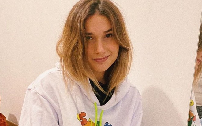 Imagem de Sasha Meneghel com o cabelo solto e um moletom branco