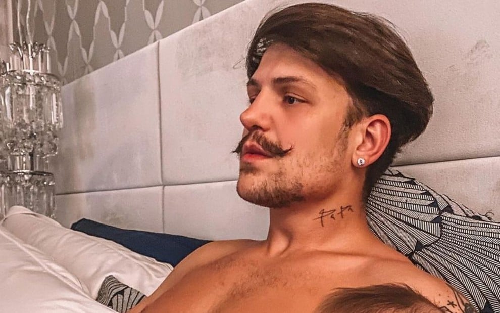 Imagem de Saulo Poncio, de bigode, deitado em sua cama