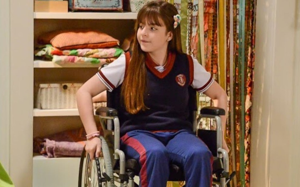 A atriz Sophia Valverde em uma cadeira de rodas como a personagem Poliana da novela As Aventuras de Poliana, do SBT