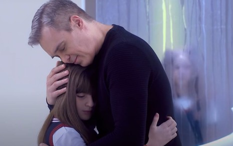 Os atores Sophia Valverde e Dalton Vigh se abraçam como os personagens da novela As Aventuras Poliana, que são filha e pai