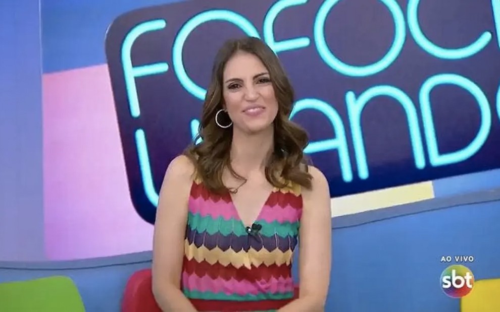 Chris Flores em registro do programa Fofocalizando: apresentadora sorri e usa regata com estampa colorida