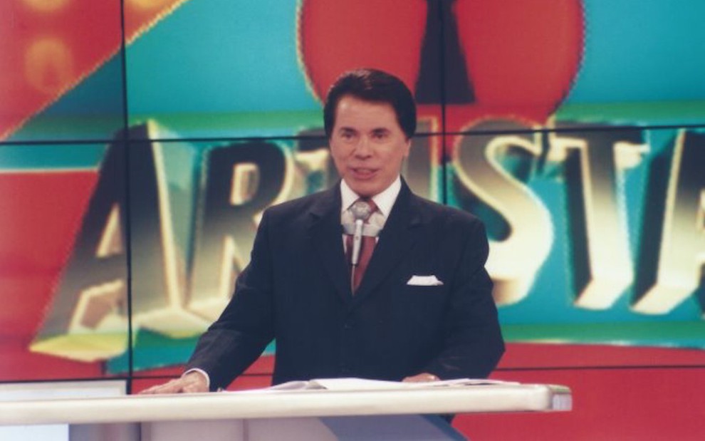 De terno e gravata, Silvio Santos em um estúdio do SBT durante apresentação da Casa dos Artistas há 19 anos