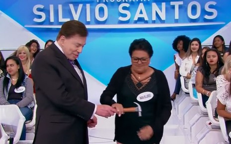 O apresentador Silvio Santos segura martelo com a fã Maria de Lurdes no Programa Silvio Santos, do SBT