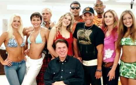 Silvio Santos sorridente reunido com o elenco da primeira Casa dos Artistas, em 2001