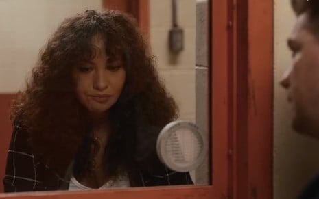 Ashley (Jasmine Cephas Jones) cabisbaixa em frente a vidro para conversar com um homem do outro lado