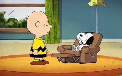 Charlie Brown no lado esquerdo observa Snoopy sentado em poltrona na sala no lado direito