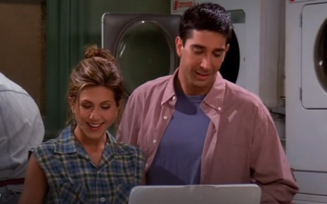 Rachel (Jennifer Aniston) no lado esquerdo de camisa xadrez e Ross (David Schwimmer) no lado direito de camisa bege e camiseta azul