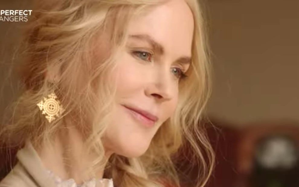Masha (Nicole Kidman) no lado esquerdo com cabelo loiro e roupa clara e expressão serena olhando para baixo