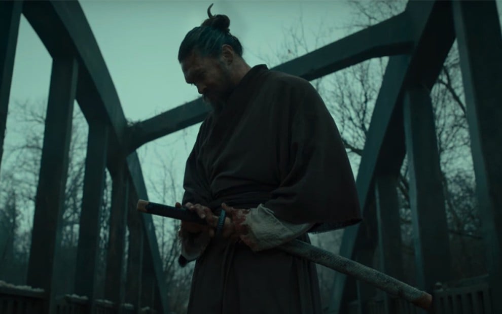 Baba Voss (Jason Momoa) de lado, em uma ponte, com uma espada na cintura em cena da segunda temporada de See