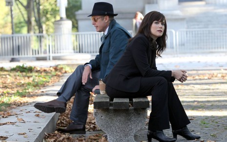 Raymond Reddington (James Spader) na esquerda e Elizabeth Keen (Megan Boone) na direita dividem o banco de uma praça em cena de The Blacklist