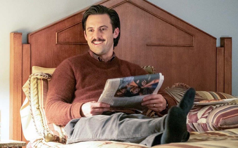 Jack Pearson (Milo Ventimiglia) deitado na cama lendo o jornal em cena de This Is Us