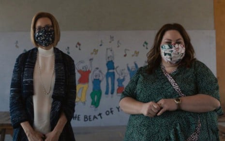 Rebecca (Mandy Moore) no lado esquerdo e Kate (Chrissy Metz) no lado direito em pátio de colégio usando máscara, em cena de This Is Us