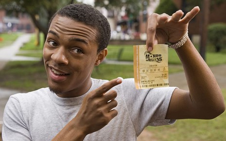 Shad Moss exibe um bilhete amarelo em cena como Kevin Carson do filme Bilhete de Loteria (2010)
