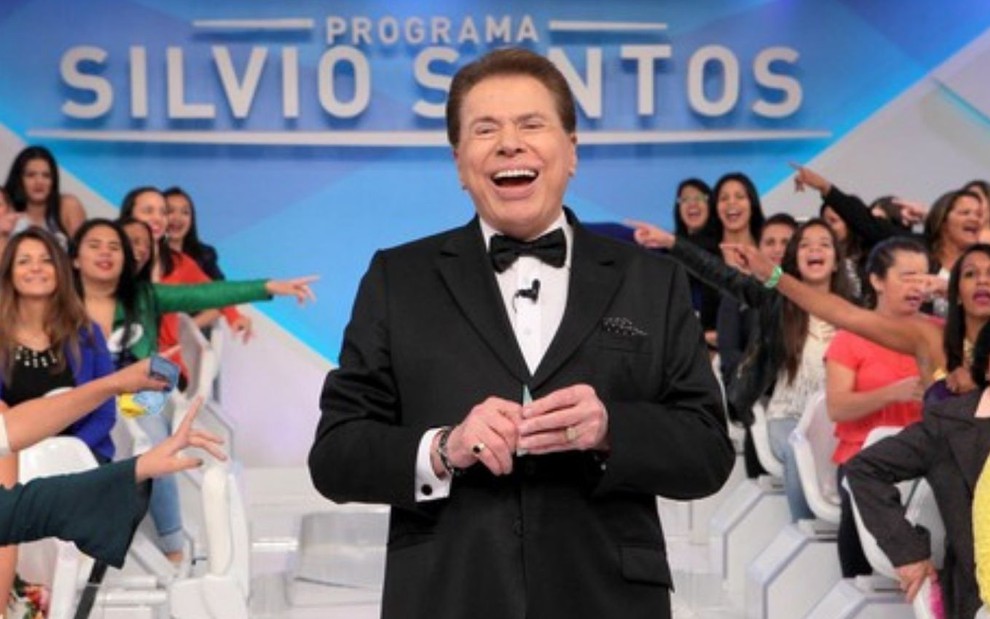 Silvio Santos sorrindo no palco de seu programa no SBT