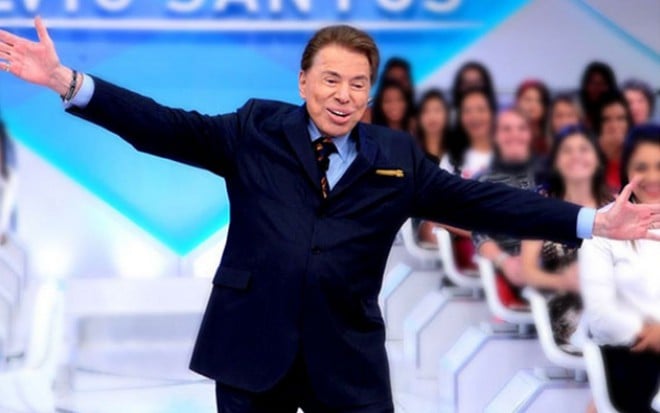 Com os braços abertos, Silvio Santos brinca no estúdio de seu programa no SBT