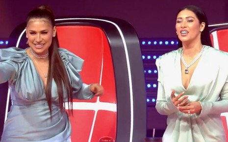 As técnicas Simone e Simaria com vestidos cinza no cenário do The Voice Kids