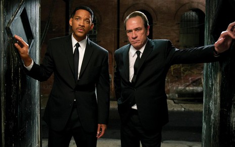 Will Smith e Tommy Lee Jones em cena de Homens de Preto 3, caracterizados como seus personagens