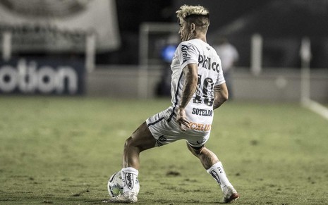 O jogador do Santos, Soteldo,  em lance no campo vestido com o uniforme do time nas cores branco e preto