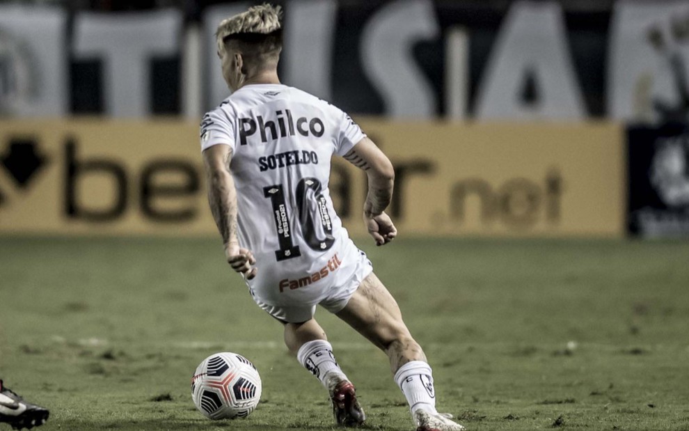 O jogador do Santos Soteldo em lance no campo, vestido com o uniforme do time nas cores branco e preto