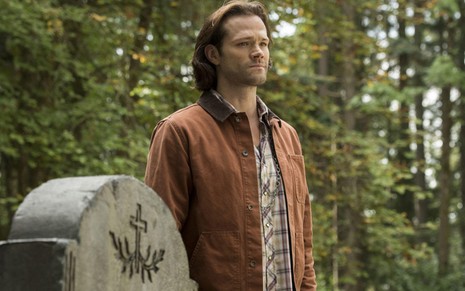 O ator Jared Padelecki ao lado de uma lápide em um cemitério na 15ª e última temporada de Supernatural