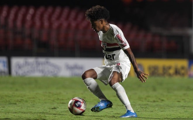 O jogador Tchê Tchê em lance pelo São Paulo vestindo o uniforme branco do time