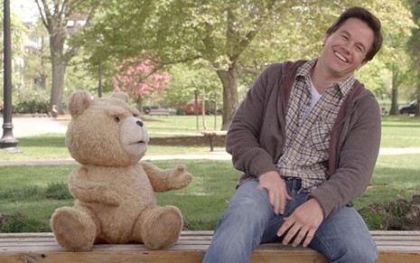 Ted (Seth MacFarlane)  e Mark Wahlberg sentados em um banco em cena do filme Ted