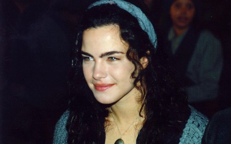 A atriz Ana Paula Arósio com leve sorriso, caracterizada como Giuliana em cena de Terra Nostra